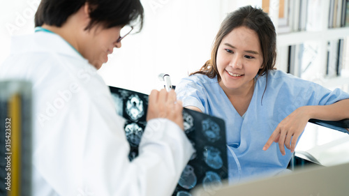 Doctor or physician take care of patient at the hospital.Beautiful female medical doctor is talking to patient reviewing brain X-ray picture radiographic image ct scan mri  isolated hospital clinic.