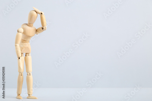 Fotografiet Wooden figure having headache on grey background