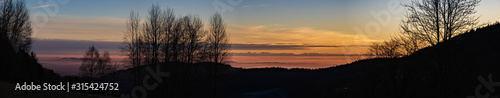 High resolution stitched panorama of a beautiful sunset with the distant alps in the background near Daxstein, Bavarian forest, Bavaria, Germany