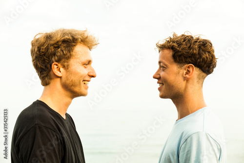 Portrait of strawberry blonde young men, face to face