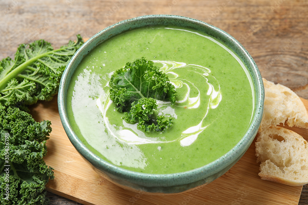 Tasty kale soup with cream on wooden table Tasty kale soup with cream on wooden table