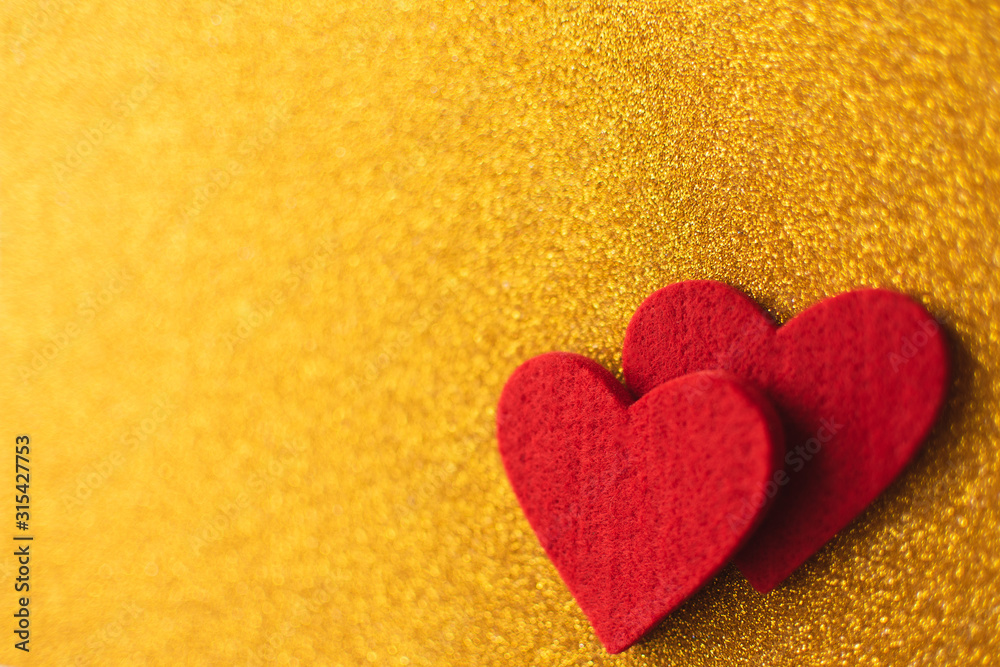 Obraz premium Red felt hearts on golden shiny background. Valentine's Day