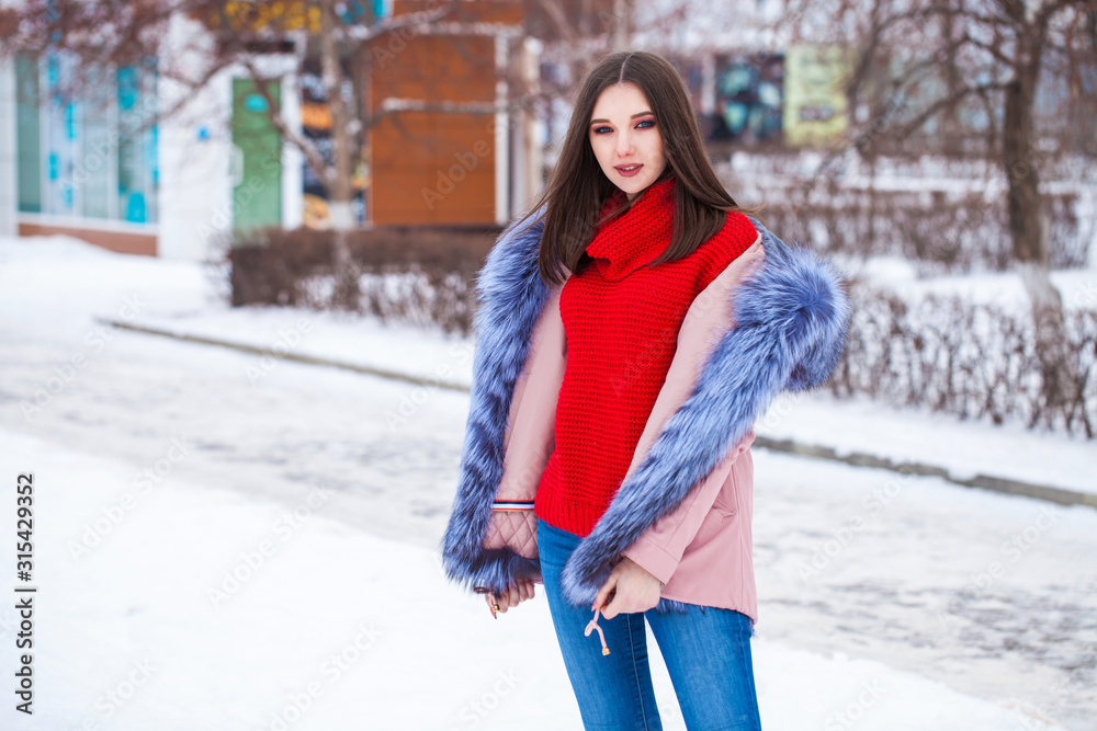 Young blonde woman in blue down jacket in winter street Young blonde woman in blue down jacket in winter street