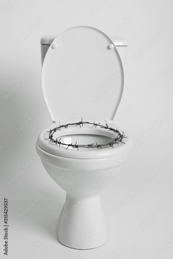 Toilet bowl with barbed wire on white background. Hemorrhoids concept Stock  Photo | Adobe Stock