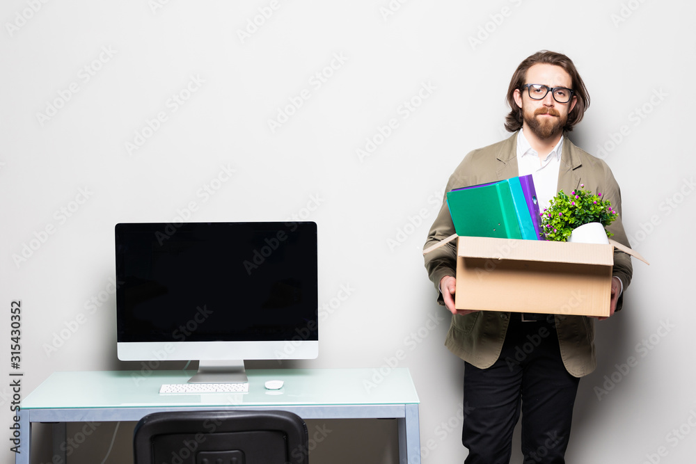 Sad businessman leaving his company while he is holding a box. Fired. Sad businessman leaving his company while he is holding a box. Fired.