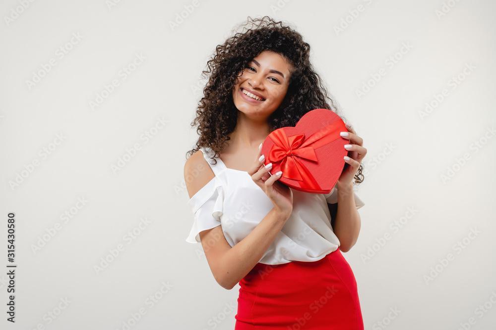 black woman smiling with red heart shaped valentine gift box isolated on white background black woman smiling with red heart shaped valentine gift box isolated on white background