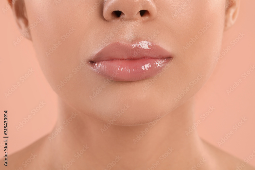 Young woman with beautiful full lips on peach background, closeup Young woman with beautiful full lips on peach background, closeup