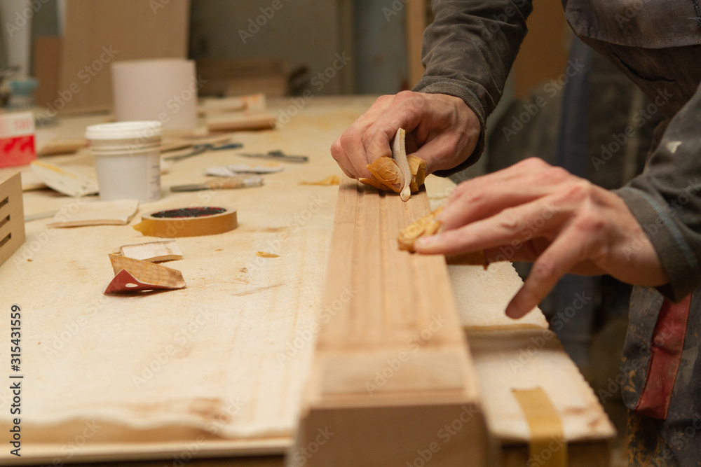 Φωτογραφία Young carpenter making wooden parts for the production of wooden furniture, joiner's shop work