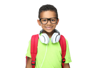 Young African American school boy in headphones with backpack on white background