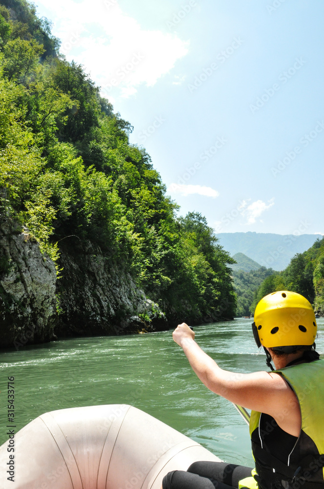 Man rafts down a mountain river amidst beautiful nature