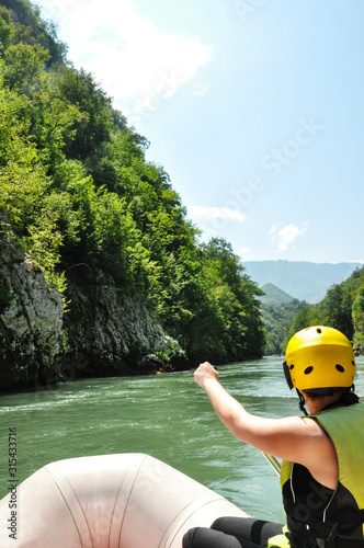 Man rafts down a mountain river amidst beautiful nature © MishAnia