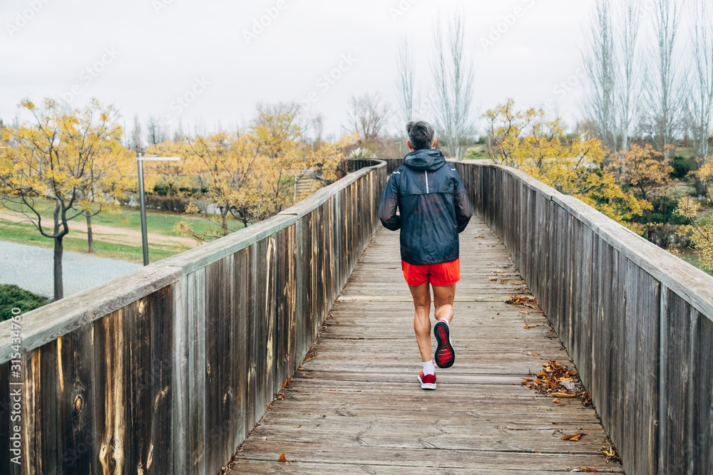 Senior retired man runs and performs exercise