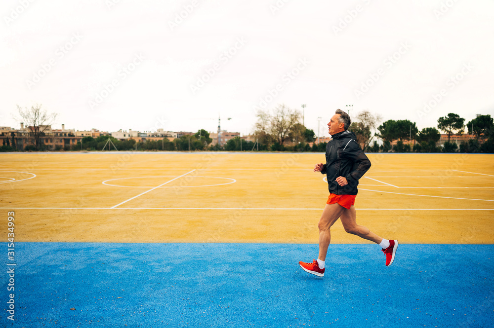 Senior retired man runs and performs exercise Senior retired man runs and performs exercise