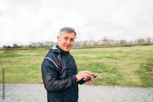 Adults athlete with his phone after running.