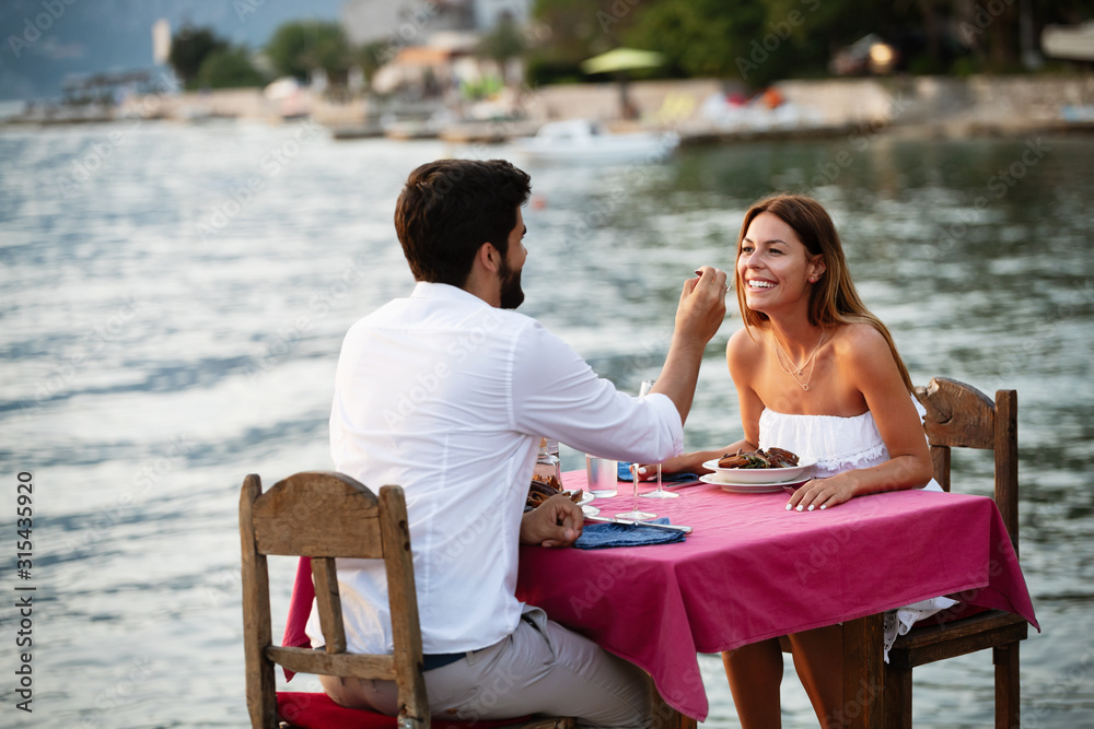 Couple sharing romantic sunset dinner on the beach