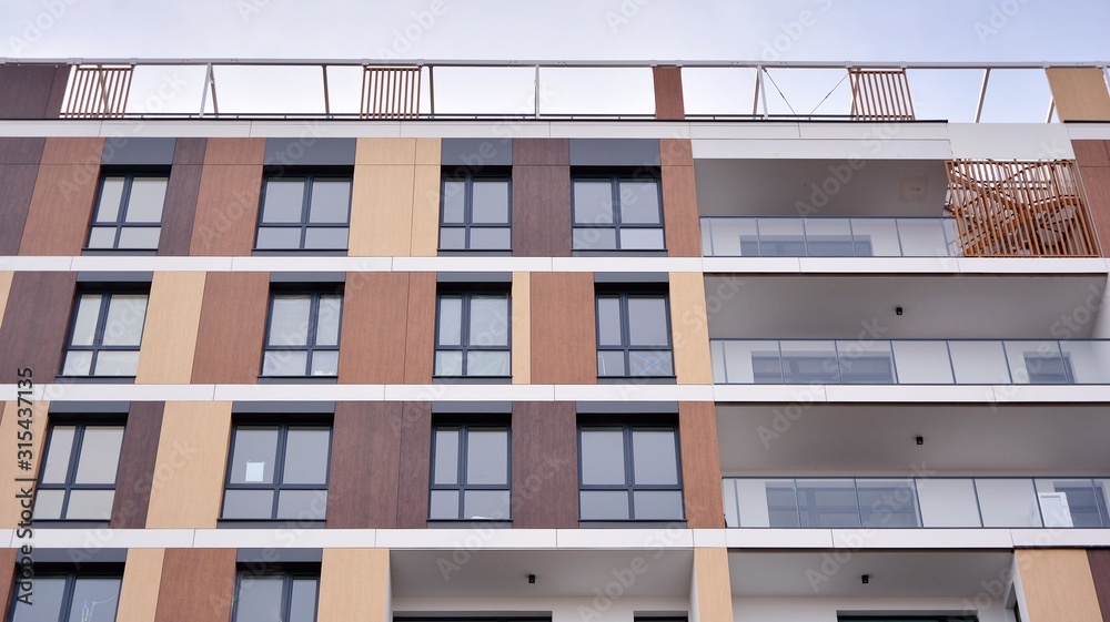 Contemporary residential building exterior in the daylight. Modern apartment buildings on a sunny day with a blue sky. Facade of a modern apartment building