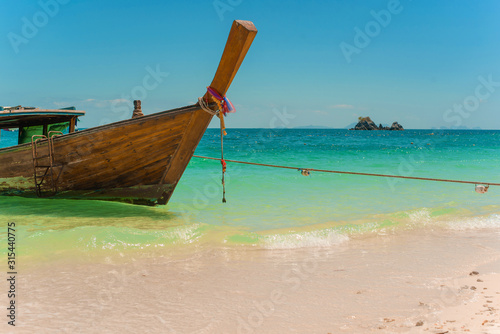 Traditional Thai longtail boat moored on exotic beach. © Elena