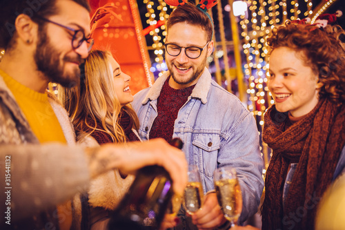 Wallpaper Mural Group of happy friends drinking champagne and celebrating New Year at the street. New year party. Torontodigital.ca