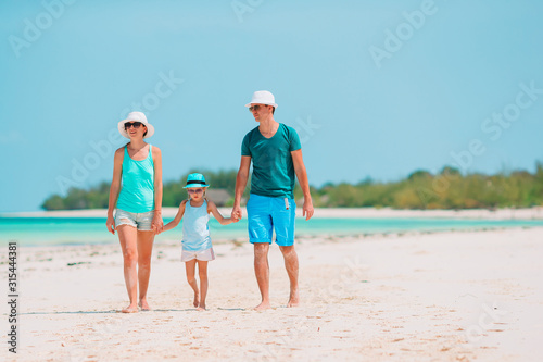 Young family on white beach during summer vacation