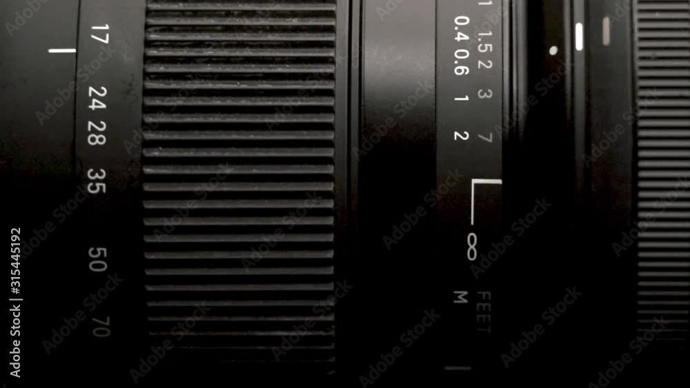 Close-up of a modern camera lens, turning of a zoom rings in shallow depth of field