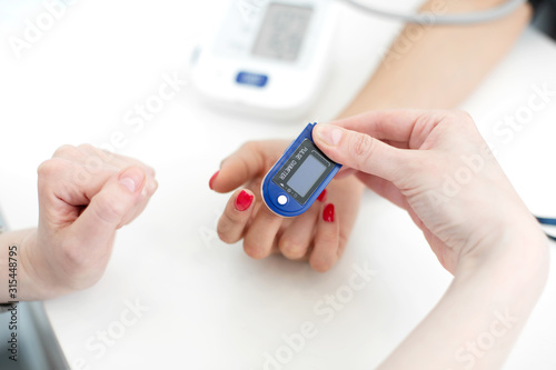 doctor puts a heart rate monitor on a patient finger