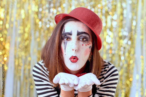 girl dressed in mime with red hat, red bow tie, striped shirt and white gloves.