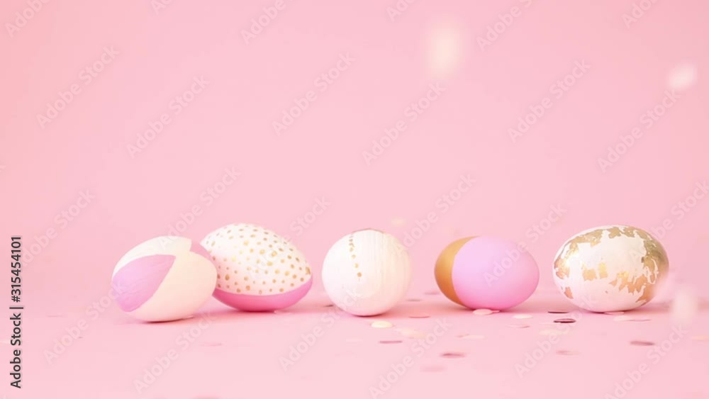 Gently pink and golden eggs spin on a pink background, slow motion. Happy Easter. Golden shine decorated eggs, golden splash conffety for ad, promotion, web Gently pink and golden eggs spin on a pink background, slow motion. Happy Easter. Golden shine decorated eggs, golden splash conffety for ad, promotion, web