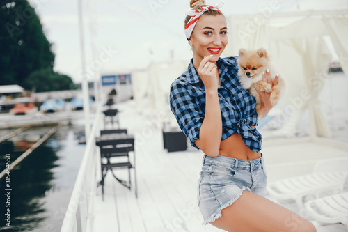 Elegant pin up lady in a shirt in a cell. Girl with cute little dog