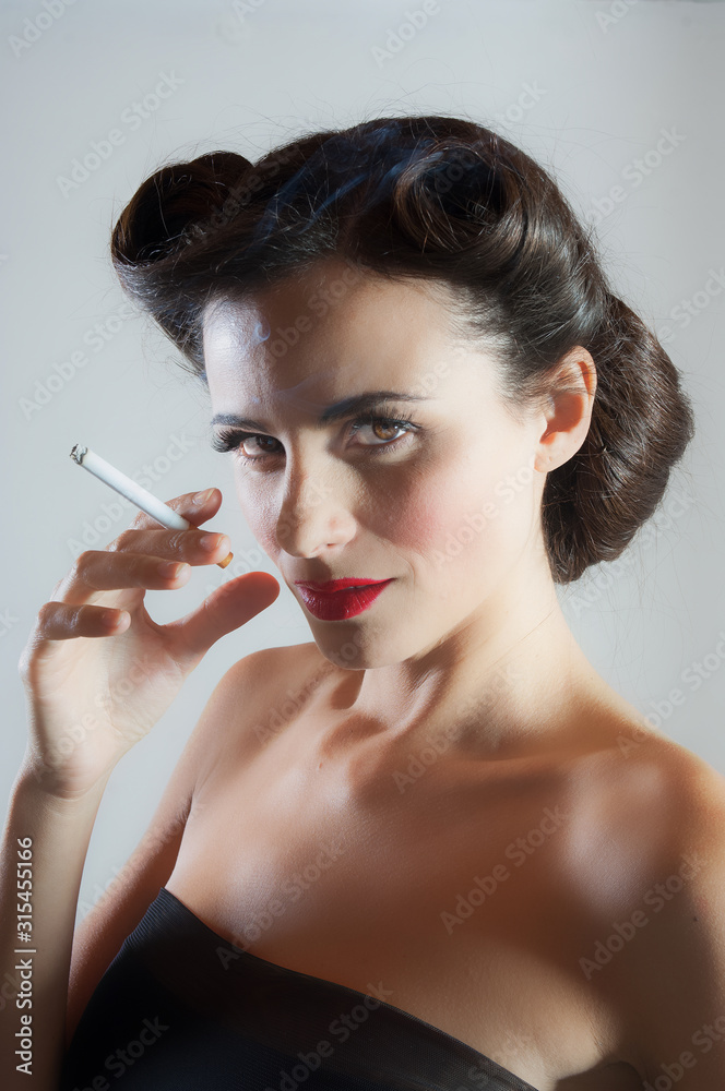Obraz premium Bella donna tiene in mano una sigaretta