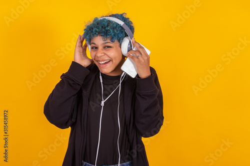 young afro american woman with mobile phone and headphones isolated on color background