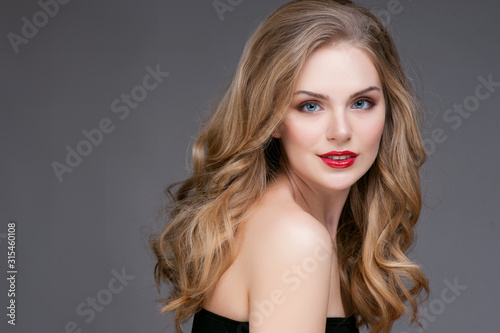 Portrait of beautiful blonde woman with curly hairstyle and bright makeup. Natural look. studio, isolated