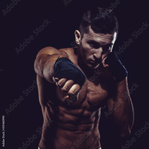 MMA Fighter Preparing Bandages For Training. Dark background