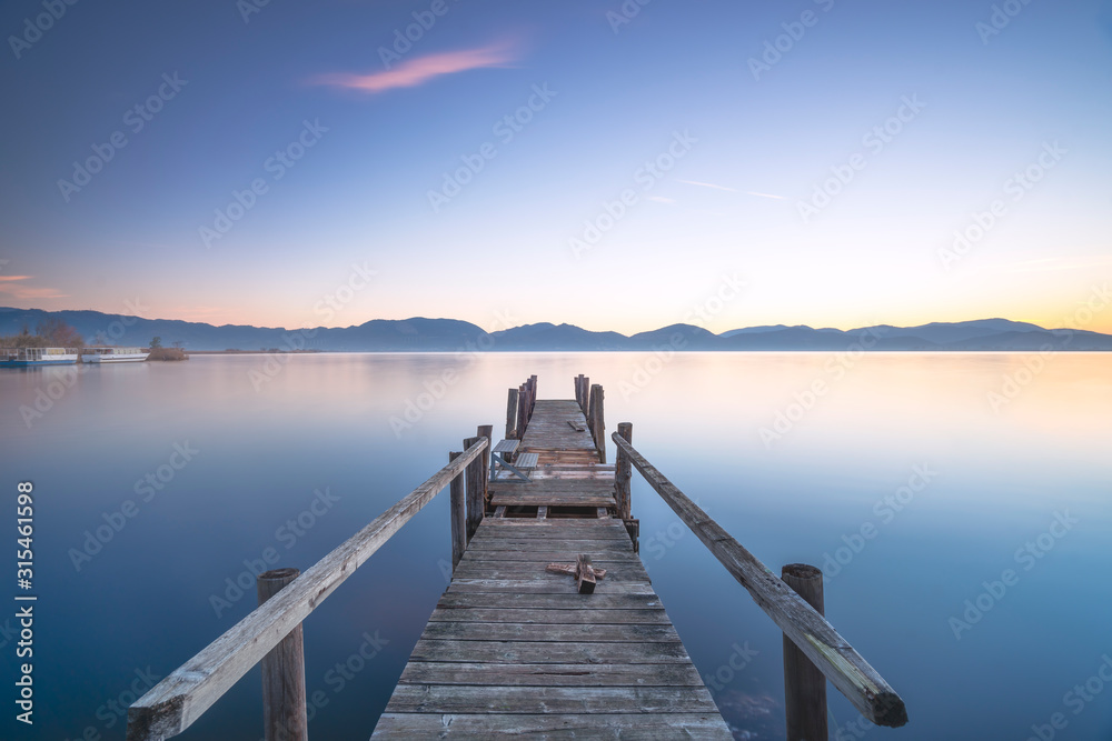 Wooden pier or jetty and lake at sunrise. Torre del lago Puccini Versilia Tuscany, Italy