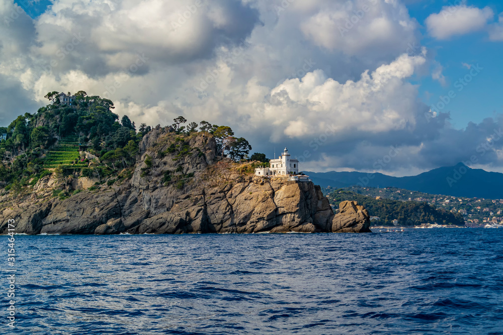 View from the boat on the white lighthouse of Portofino, Liguria - Italy