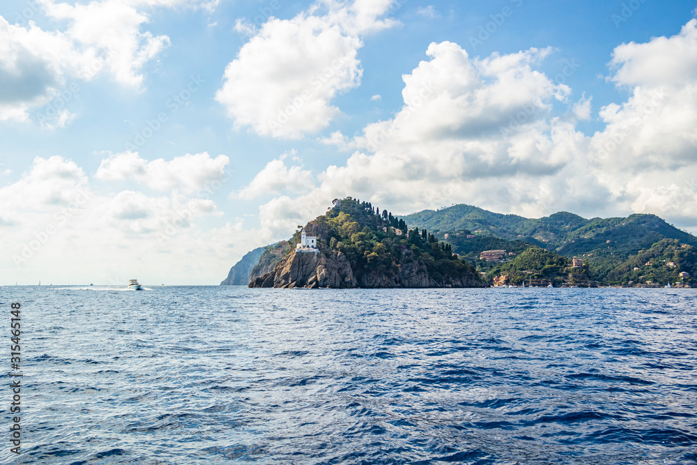 View from the boat on the white lighthouse of Portofino, Liguria - Italy