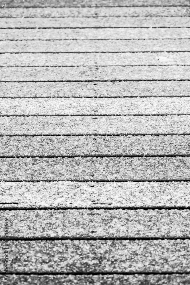 A deck section abstract of boards covered by ice with soft focus in front and rear and sharp focus in center A deck section abstract of boards covered by ice with soft focus in front and rear and sharp focus in center