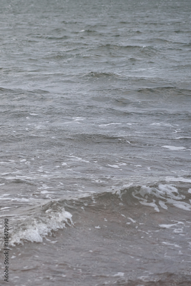 Blurred waving surface of stormy sea water on a sunset with reflection of the sunlight as a natural background. Blurred waving surface of stormy sea water on a sunset with reflection of the sunlight as a natural background.