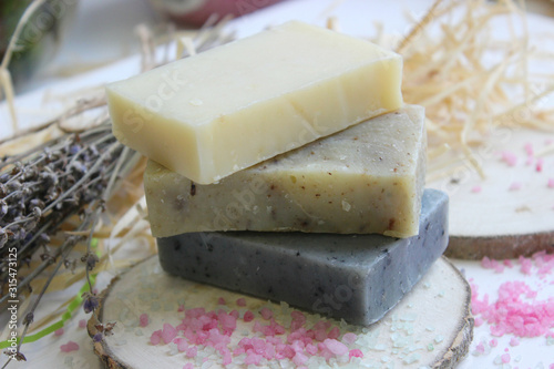 Handmade natural soap on wooden background. Spa natural treatments.Natural soap, handmade organic natural soap with body brush, oil bottle and cotton towel, spa and wellness products.