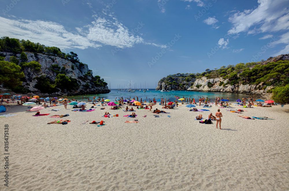 Tourists tanning in Cala Macarella in Menorca,Balearic Islands, Spain