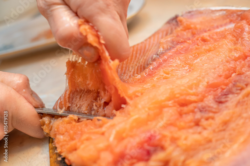 Cleaning fillet of salted pink salmon close-up