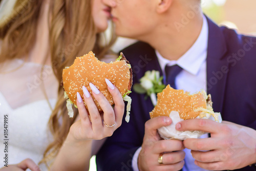 Close up of happy couple eating burgers