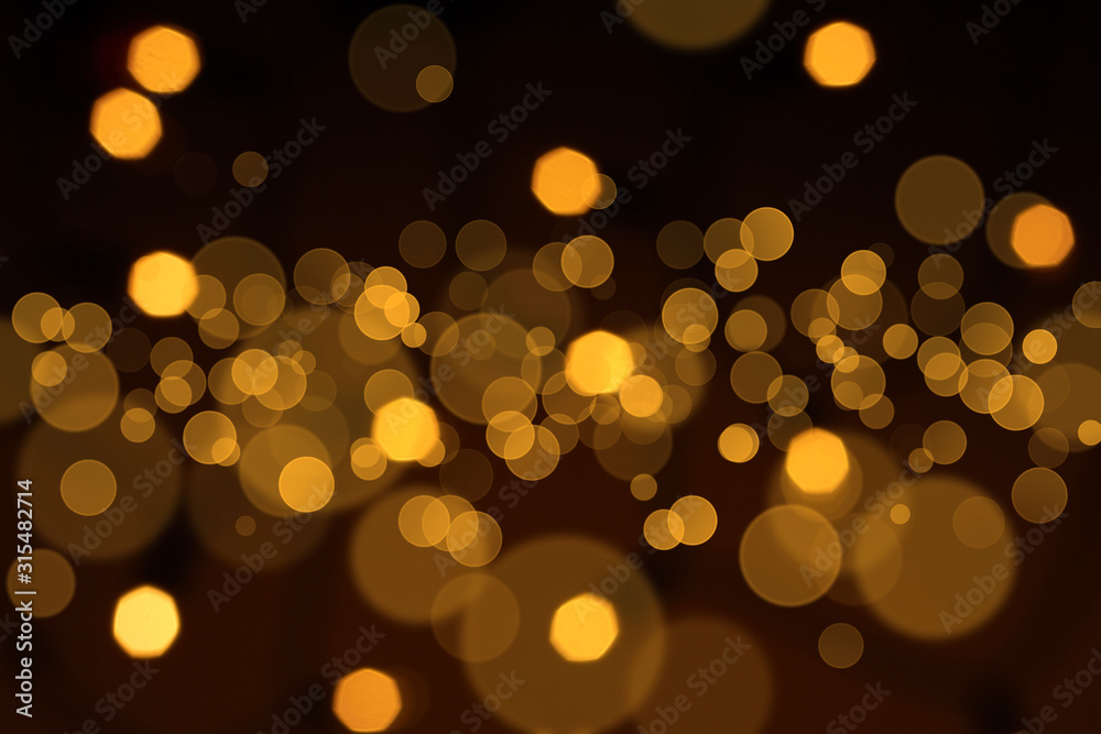 Obraz premium Golden defocused lights over black background