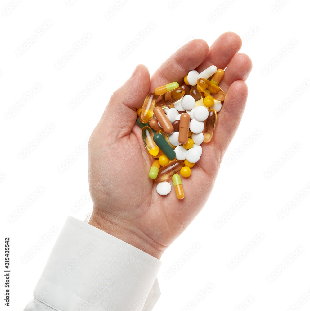 Man hand with handful of pills, tablets, vitamins, drugs, capsules isolated on white background. White shirt, business style. Health care concept. Pharmaceutical industry. Pharmacy. Man hand with handful of pills, tablets, vitamins, drugs, capsules isolated on white background. White shirt, business style. Health care concept. Pharmaceutical industry. Pharmacy.