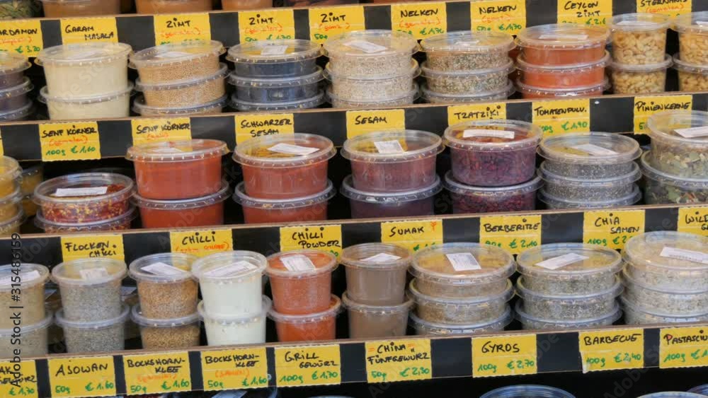 Various spices on market counter. Cilantro, hot peppers, sweet peppers, saffron, turmeric, oregano, thyme hop and more. Vienna, Austria. German price tags Various spices on market counter. Cilantro, hot peppers, sweet peppers, saffron, turmeric, oregano, thyme hop and more. Vienna, Austria. German price tags