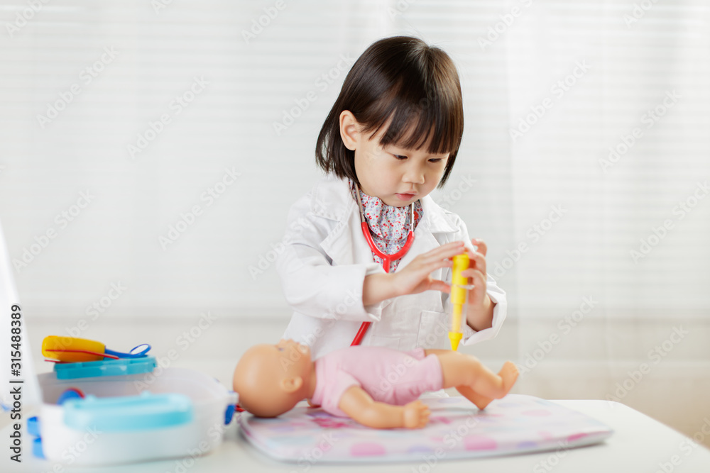 toddler girl pretend play doctor role at home against white background toddler girl pretend play doctor role at home against white background