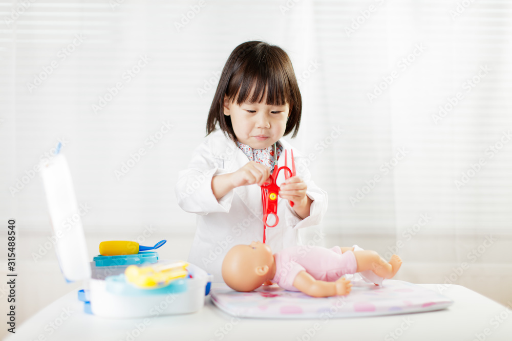 toddler girl pretend play doctor role at home against white background toddler girl pretend play doctor role at home against white background