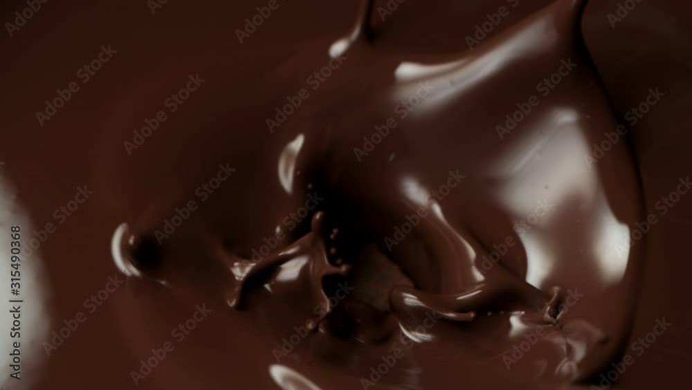 Super Slow Motion Shot of Raw Chocolate Chunks Falling into Melted Chocolate at 1000fps. Super Slow Motion Shot of Raw Chocolate Chunks Falling into Melted Chocolate at 1000fps.