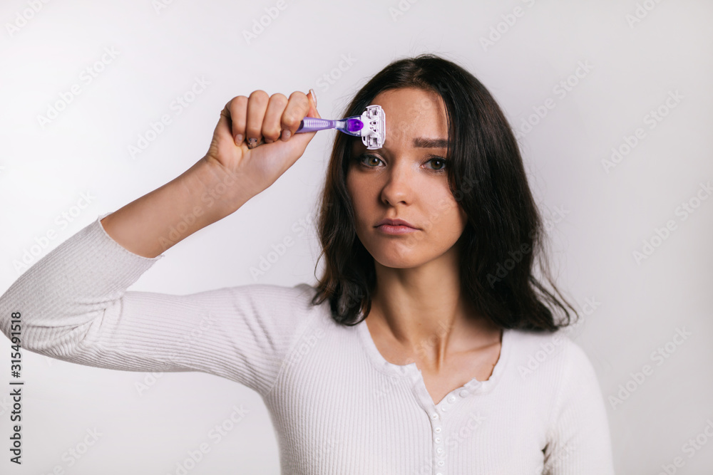 Naklejka premium girl shaves herself one eyebrow