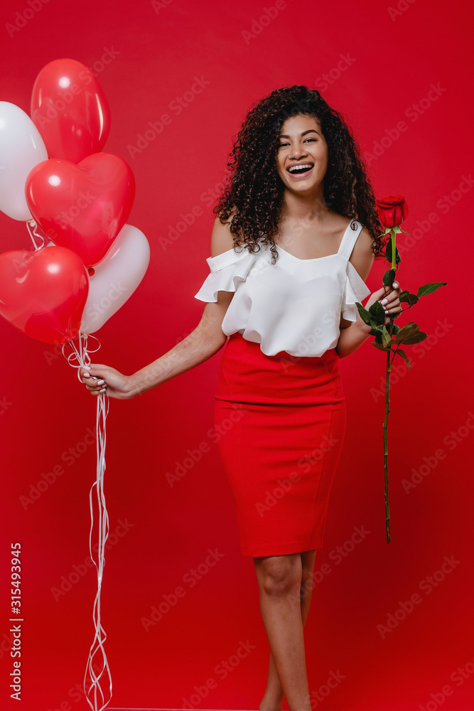 beautiful black woman with rose and heart shaped balloons isolated on red beautiful black woman with rose and heart shaped balloons isolated on red