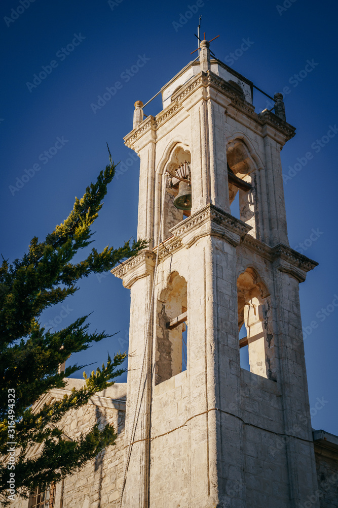 The bell tower of the old church against the sky.